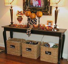 a table with baskets and pictures on it in front of a framed photo above the table