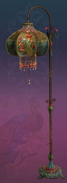 a lamp with a peacock on it and a bird decoration hanging from the top, in front of a purple background