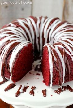 a red velvet bundt cake with white icing and chocolate drizzles