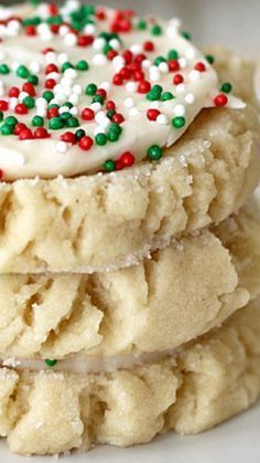 three cookies stacked on top of each other with sprinkles and white frosting