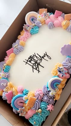 a birthday cake in a box with the words happy birthday written on it and lots of colorful icing