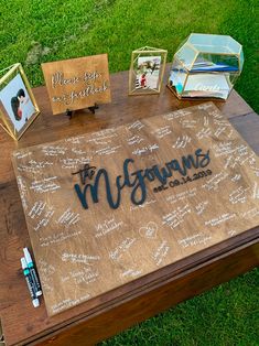 a wooden table topped with pictures and writing on top of green grass covered in dirt