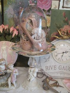 a table topped with figurines and a clochet covered in glass dome