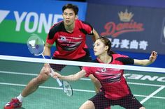 two people playing tennis on a court with one holding the racket in his hand