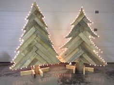 two wooden christmas trees with lights on them