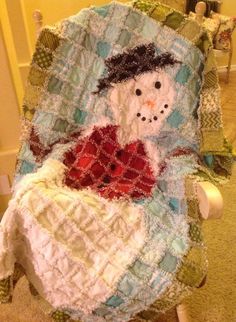 a quilted snowman is sitting in a chair