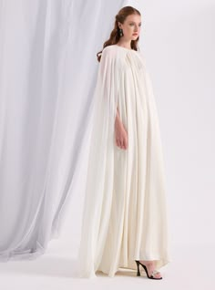 WF ATELIER Model height: 177 CM 100% Polyester Length: 145 cm Flowy Formal Dress With Cape Sleeves, White Cape Dress For Spring, Spring Cape Dress In White, White Cape Sleeve Dress For Evening, White Cape Sleeve Evening Dress, White Dresses With Cape Sleeves, Pre-draped Long Sleeve Wedding Dress, White Cape Dress, White Cape