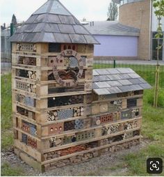 a building made out of wooden pallets with a clock on top