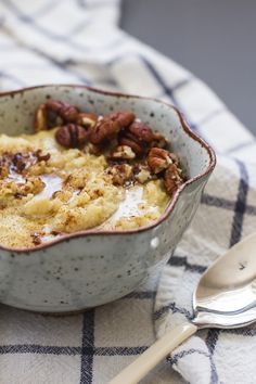 a bowl filled with food sitting on top of a checkered table cloth next to a spoon