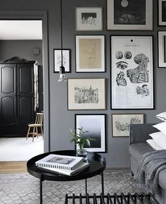 a living room with gray walls and pictures on the wall