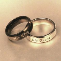 two wedding rings with the words her king and his queen engraved on them, sitting next to each other