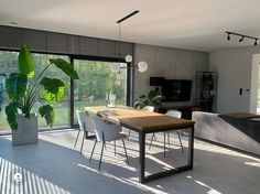 a dining room table and chairs in front of large windows