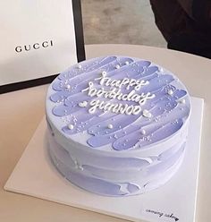 a blue birthday cake sitting on top of a table