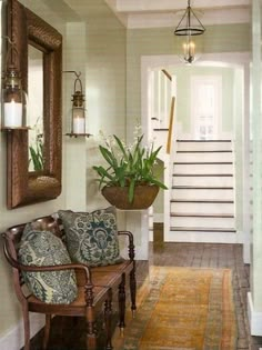 a living room with a couch, mirror and plants on the wall next to it