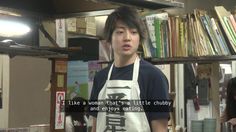 a man with an apron standing in front of a bookshelf