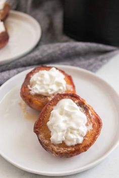 two small pastries on a plate with whipped cream