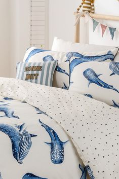 a bed with blue and white whale print on it