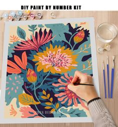 a person is painting flowers on a canvas with paintbrushes and watercolors