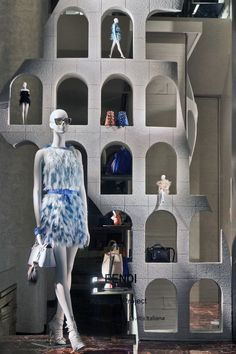 mannequins are dressed in blue and white outfits, standing next to shelves