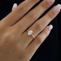 a woman's hand with a diamond ring on it