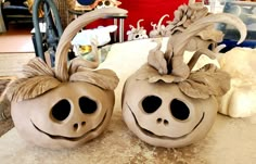 two clay pumpkins sitting on top of a table