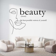 a living room filled with furniture and a wall decal that says beauty on it