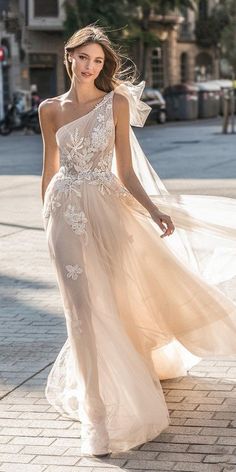 a woman in a wedding dress walking down the street