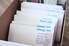 a box filled with lots of white envelopes and writing on the inside of it