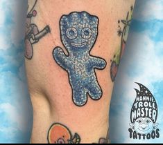 a person with tattoos on their legs has a blue teddy bear and other things around them