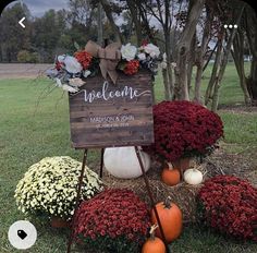 a welcome sign surrounded by flowers and pumpkins