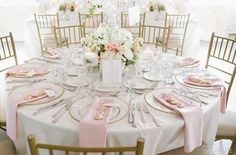 the table is set with pink and white flowers