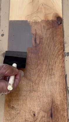 a person using a paint roller to finish a piece of wood