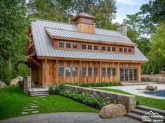 a large wooden house with a pool in the yard and stone steps leading up to it