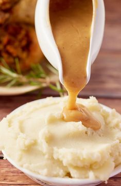 mashed potatoes with gravy being poured onto them