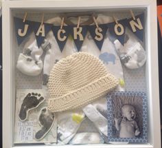 a baby's birth gift set in a shadow box with clothes and socks on it