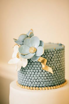 a blue and white cake with flowers on top