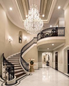 an elegant foyer with chandelier and marble floors