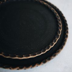 three black plates stacked on top of each other with brown circles around the rims