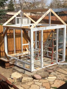 a house being built in the backyard with wood framing and roof trussing on it