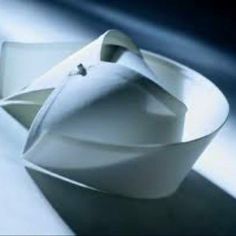 an origami boat is floating on the water and it appears to be made from paper