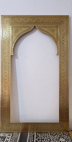 an ornate gold frame on a white wall