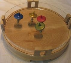 a round wooden tray with four different colored knobs on the top and one in the middle