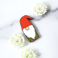 an image of a gnome brooch with flowers in the background