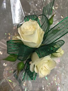 two white roses with green ribbons and sequins