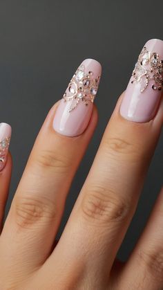 a woman's hand with pink and white nail polishes on her nails, decorated with crystal stones