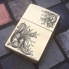 a gold colored zippo lighter sitting on top of a stone floor