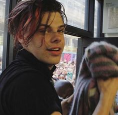 a young man with red hair and eye makeup