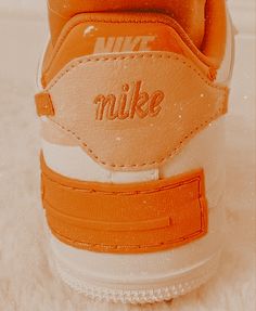 an orange and white nike sneaker with the word nike on it's side