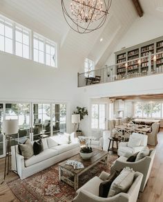 a living room with white furniture and lots of windows