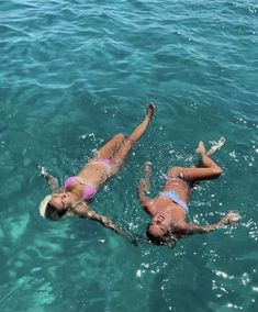 two women are swimming in the ocean together